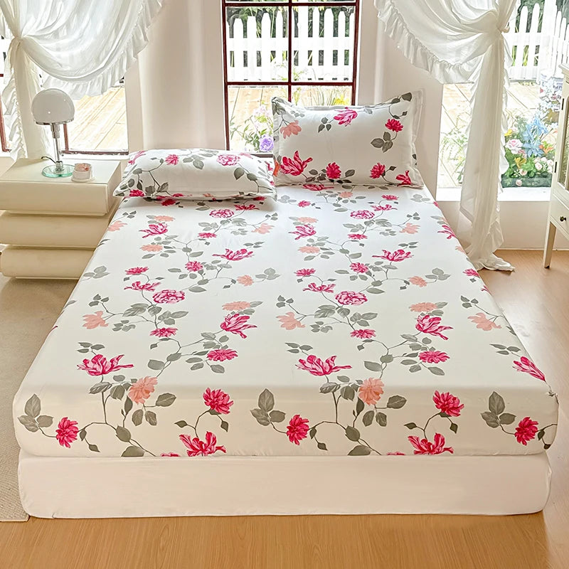 Floral patterned bed sheet set on a bed in a bright room with curtains.